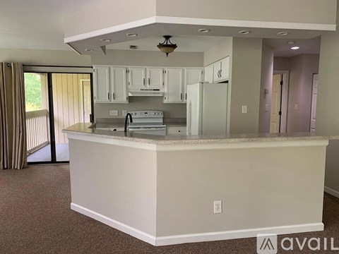 A kitchen with white cabinets and appliances is available for rent.