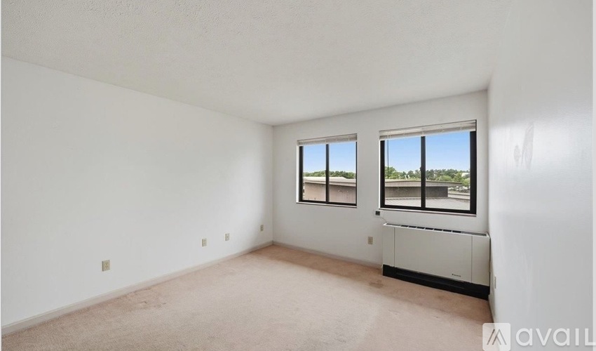 A spacious room with a window and a wall-mounted air conditioning unit.