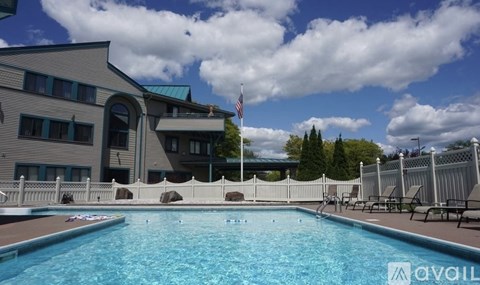 A swimming pool in front of a building with a flag on top.