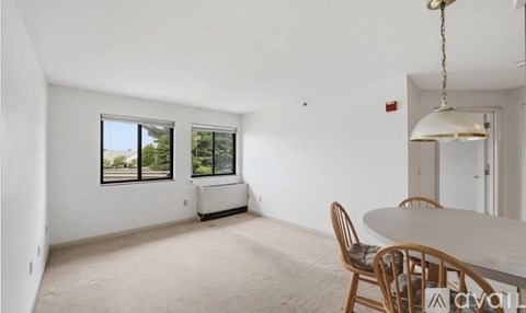 A room with a table and chairs and a window.