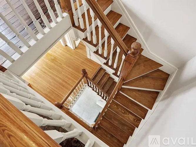 A wooden staircase with white railings.