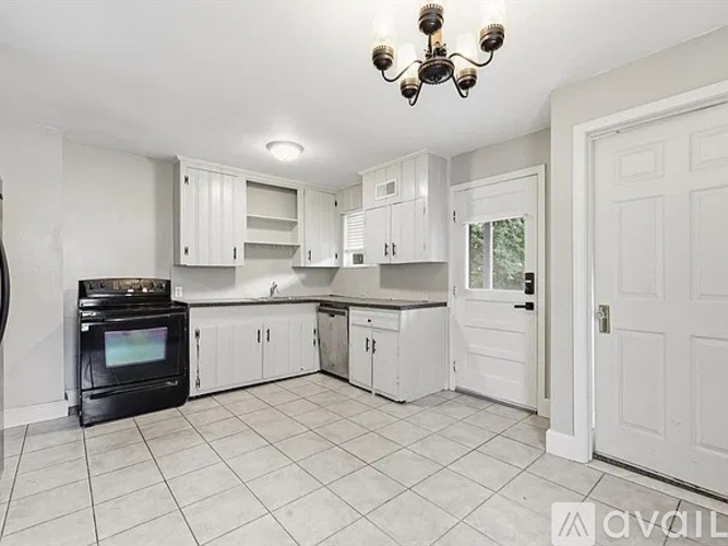 A kitchen with white cabinets and a black stove top oven.