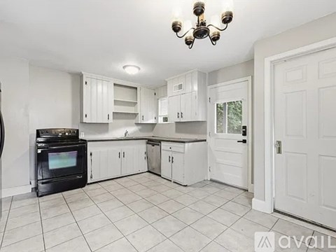 A kitchen with white cabinets and a black stove top oven.