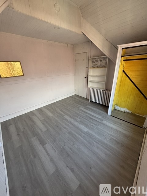 A room with wooden flooring and a white ceiling.