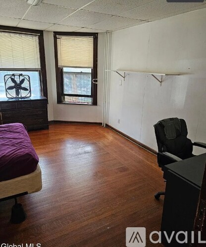 A room with a bed, desk, and chair.