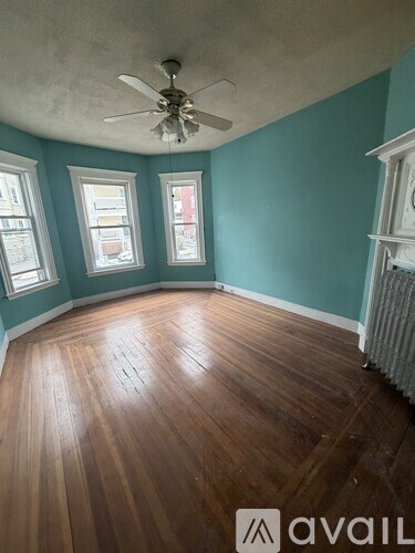 A room with wooden floors and a ceiling fan.