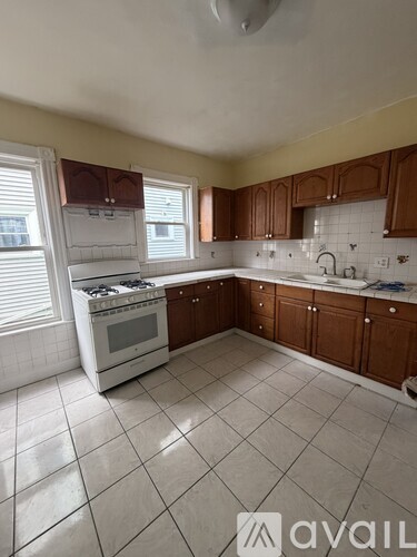 A kitchen with white appliances and brown cabinets.