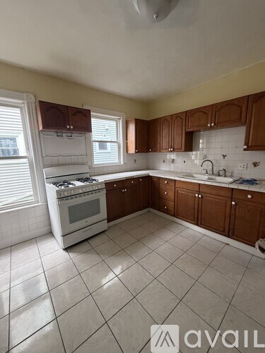 A kitchen with white appliances and brown cabinets.