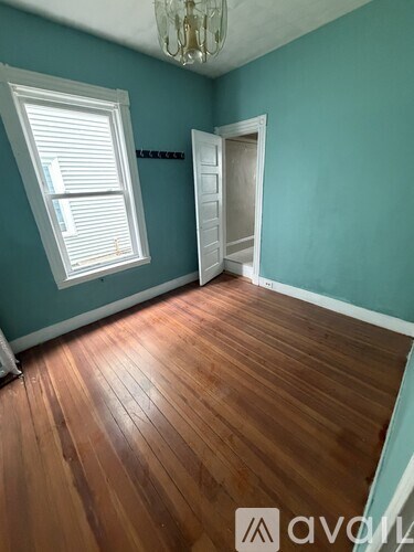A room with wooden floors and a chandelier.