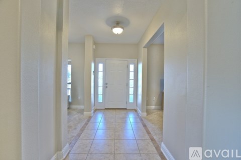 A hallway with a tiled floor and white walls.