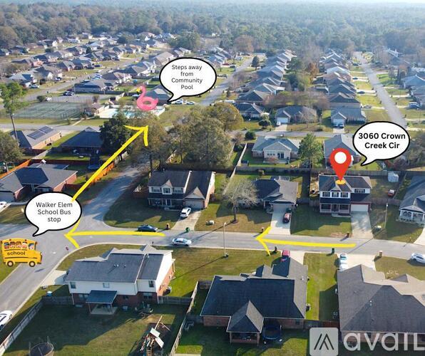 An aerial view of a neighborhood with a school bus stop and a creek.