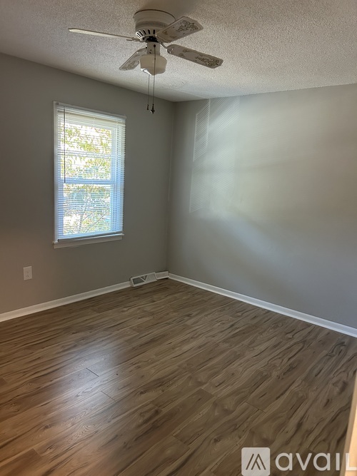 A room with a ceiling fan and a window.