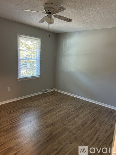 A room with a ceiling fan and a window.