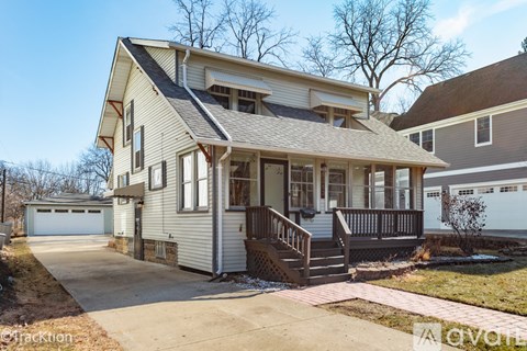 A two-story house with a garage and a covered porch.