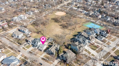 An aerial view of a neighborhood with a pink marker indicating a specific house.