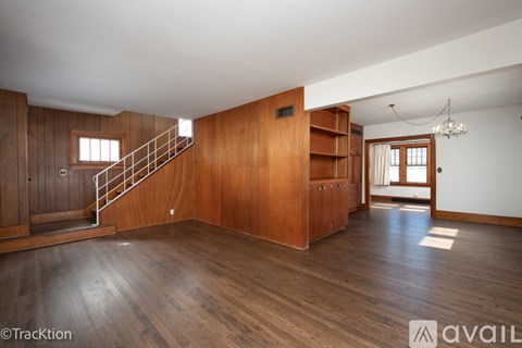 A wooden room with a staircase and a chandelier.
