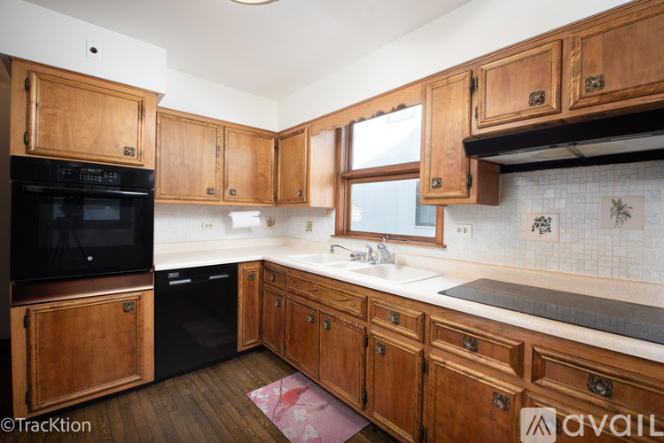 A kitchen with wooden cabinets and a black oven.