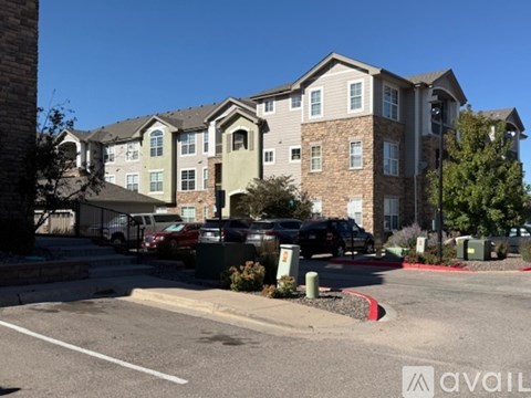 A large apartment complex with a parking lot in front.