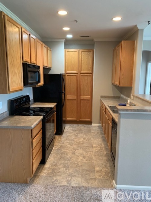 A kitchen with wooden cabinets and black appliances.