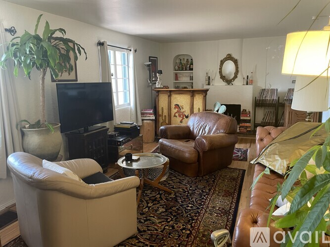 A living room with a brown leather chair and a white sofa.