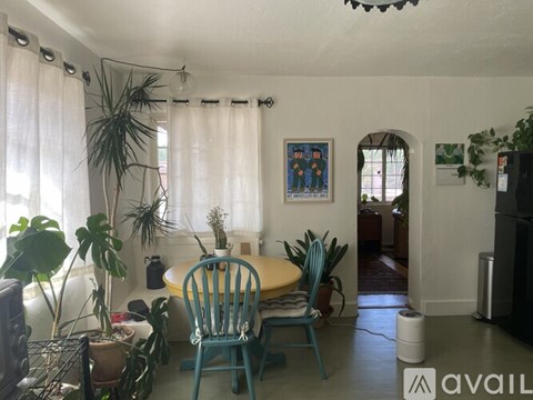 A room with a table and chairs and a painting on the wall.