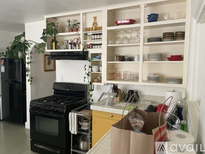 A kitchen with a black stove and white cabinets.