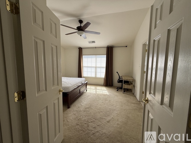 A bedroom with a bed, desk, and chair.