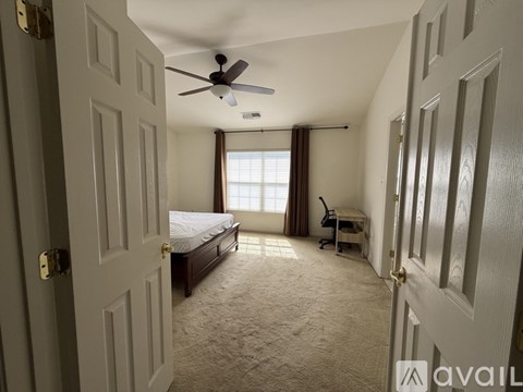 A bedroom with a bed, desk, and chair.