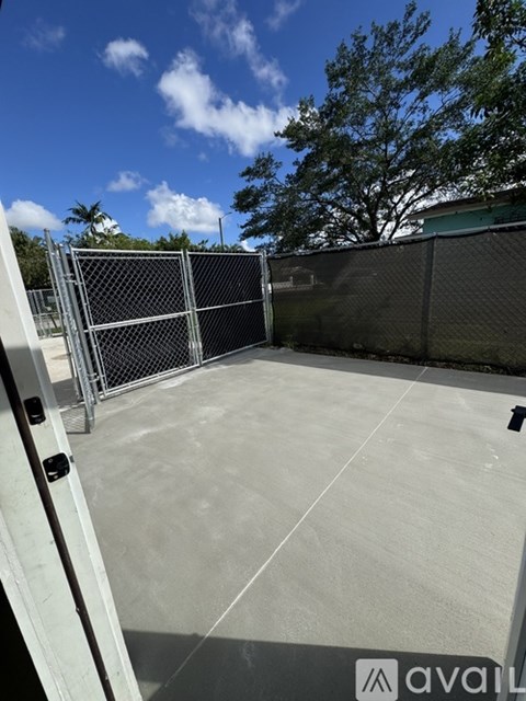 A concrete patio with a metal fence and gate.