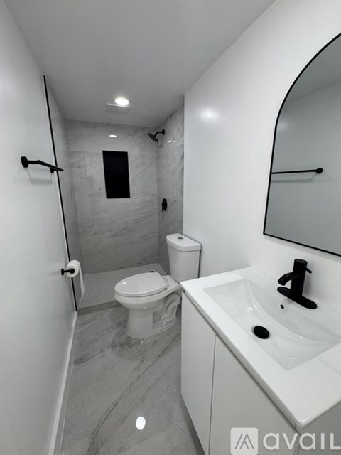 A bathroom with a toilet, sink, and shower.