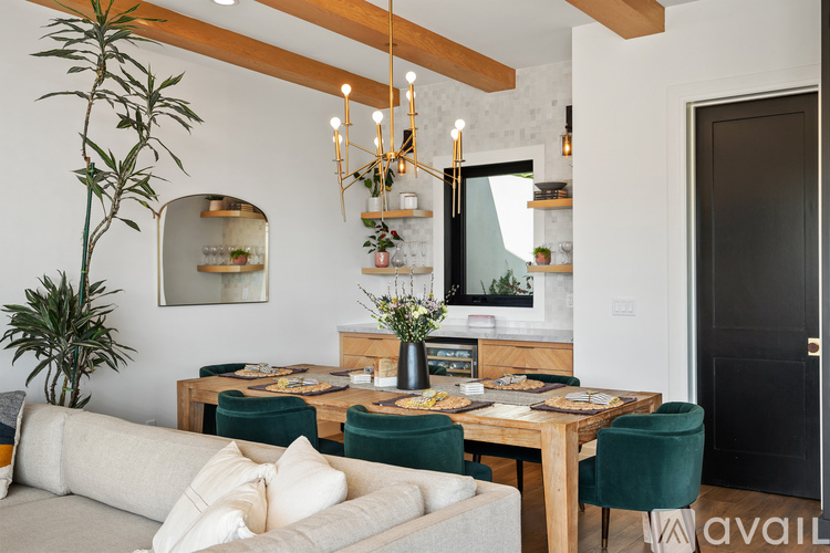 A dining area with a wooden table surrounded by green chairs.