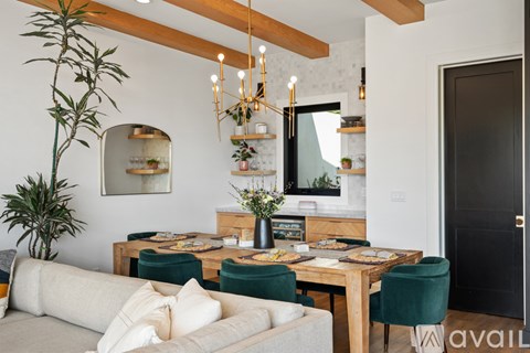 A dining area with a wooden table surrounded by green chairs.