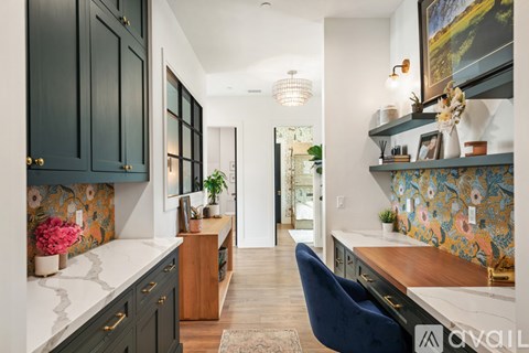 A kitchen with dark cabinets and a blue chair.