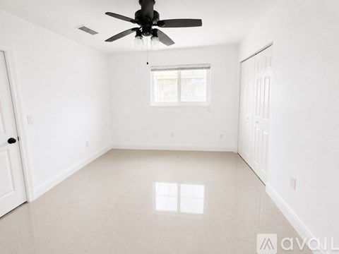 A spacious room with a ceiling fan and a window.