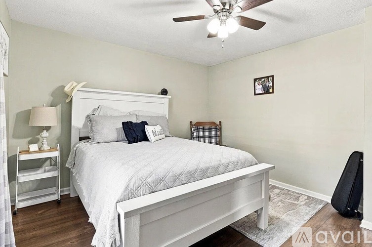 A bedroom with a bed, nightstand, and a ceiling fan.