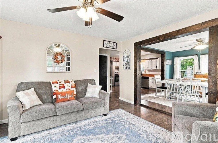 A living room with a grey couch and a ceiling fan.