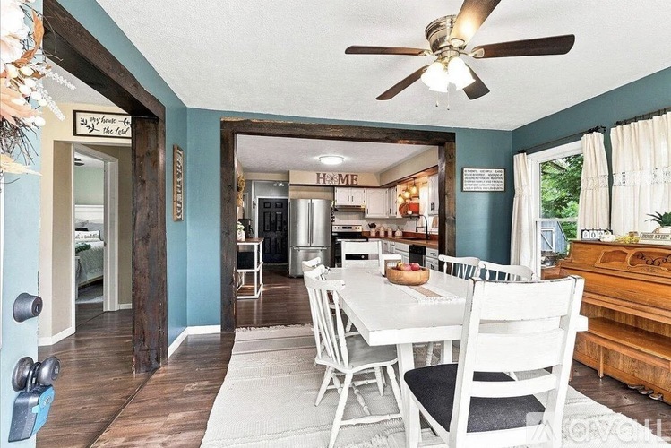 A dining room with a white table and chairs.