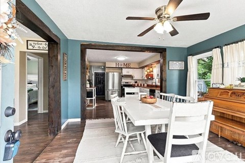 A dining room with a white table and chairs.