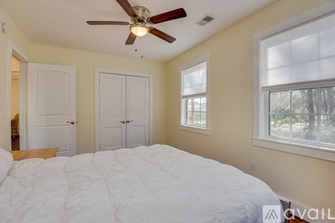 A bedroom with a large bed and a ceiling fan.