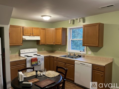 A kitchen with wooden cabinets and a white stove top oven.