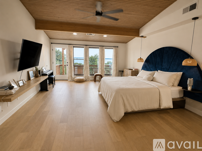A bedroom with a large bed and a flat screen TV.