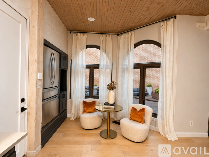 A modern kitchen with a wooden ceiling and a dining area with a table and chairs.