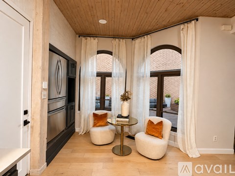 A modern kitchen with a wooden ceiling and a dining area with a table and chairs.