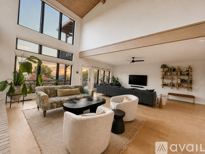 A living room with a black sofa and a wooden floor.