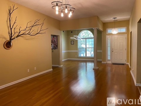A room with wooden floors and a wall-mounted branch decoration.