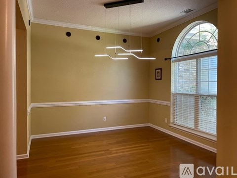 A room with a large window and a wooden floor.