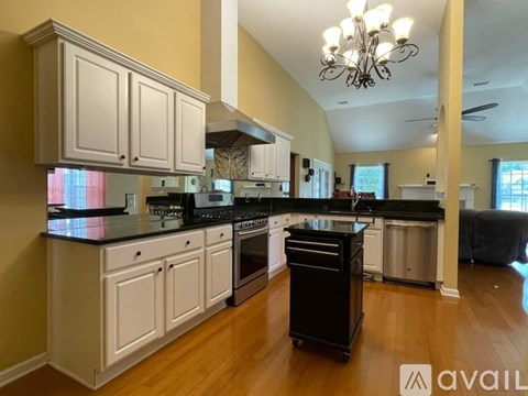 A kitchen with white cabinets and black countertops.