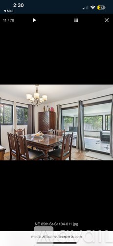A dining room with a wooden table and chairs.