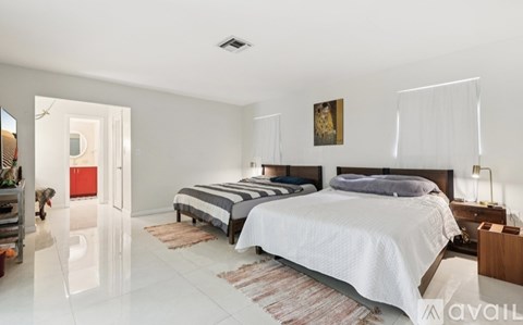 A bedroom with two beds and a painting on the wall.
