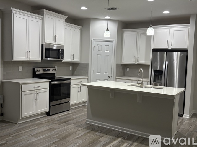 A kitchen with white cabinets and a large island.